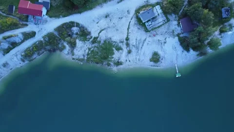 Aerial view from above of a turquoise lake in an old quarry, surrounded by a Stock-Footage 294590953