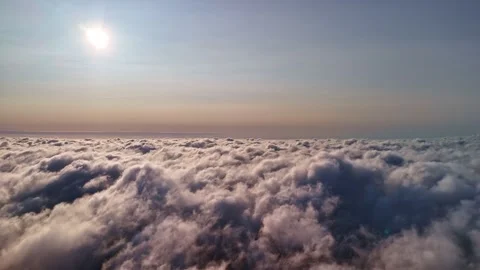 Aerial view above a vast cloud layer in soft sunlight, capturing a peaceful 库存影片 334018725