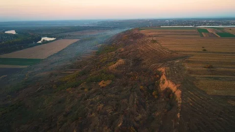 Aerial view of an abrupt hill with fields on top. Stock Footage 114424776