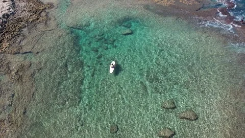 An aerial view of Achziv beach in Israel with a man on a SAP drone view from Stock Footage 251003353