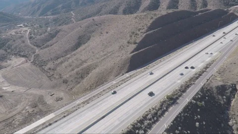 Aerial view across a freeway overpass in the Southern California desert Stock Footage 92108710