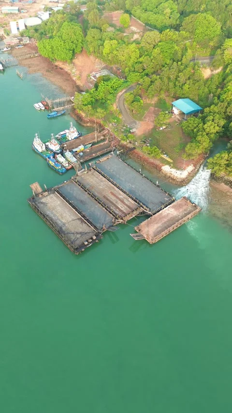Aerial View of Active Coastal Waterfront: Docks, Vessels, and Verdant Shore.. Stock-Footage 337281013