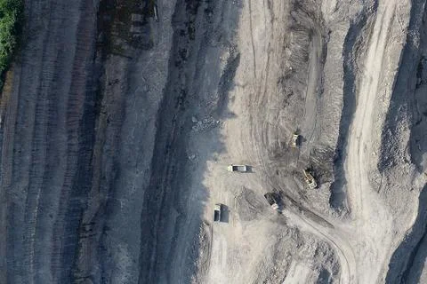 Aerial view of active earthmoving construction with excavator, dump trucks Foto stock