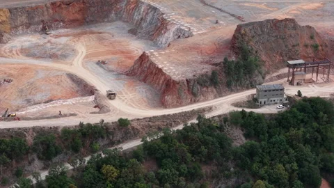 An aerial view of an active open pit quarry showing heavy machinery and dump Stock Footage 340896794