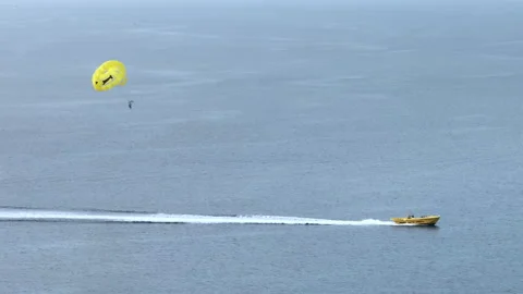 Aerial view active recreation of flying on a parachute attached to a boat. Stock Footage 254564251