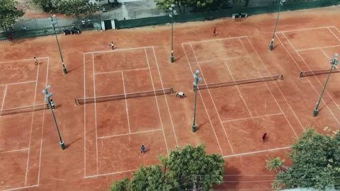 Aerial View of Active Red Clay Tennis Courts Surrounded by Green Trees Stock Footage 337127491
