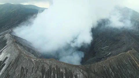 Aerial view of active volcano crater emitting thick white smoke into sky Video stock 295763691