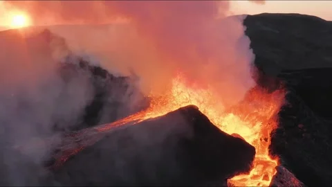 Aerial view of active volcano eruption with lava flow and thick smoke at sunset Stockbeeldmateriaal 344214638