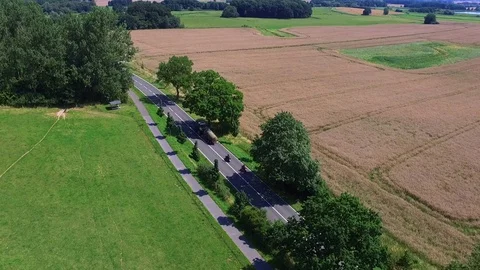 Aerial view of  agricultural fields along a Country Road - tractor is passing by Stock Footage 71198997