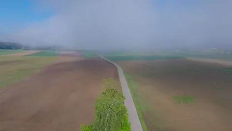 Aerial view of agricultural fields and road under fog, Switzerland. Stock Footage 334914990