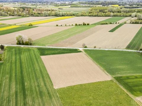 Aerial view of agricultural fields featuring a patchwork of green and brown Stock Photos