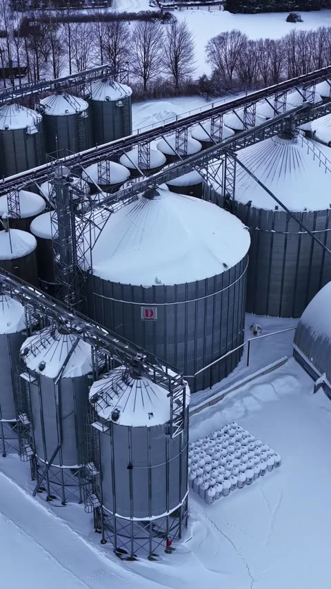 Aerial view of agricultural grain elevators covered with snow during winter Stock Footage 336241187