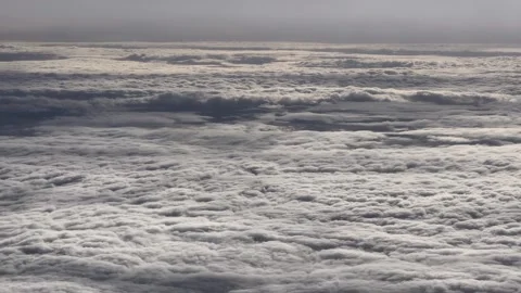 Aerial view from airplane of cumulus cloudscape seen from a window plane Video stock 323888974