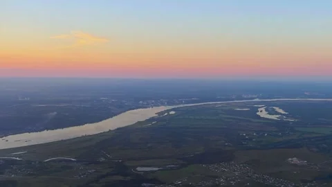 Aerial view from airplane window above green ground, city and river. Air travel. Stock Footage 283922745