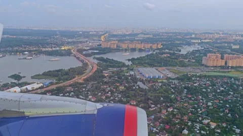 Aerial view from airplane window above green ground, city and river. Air travel. Stockbeeldmateriaal 284872817