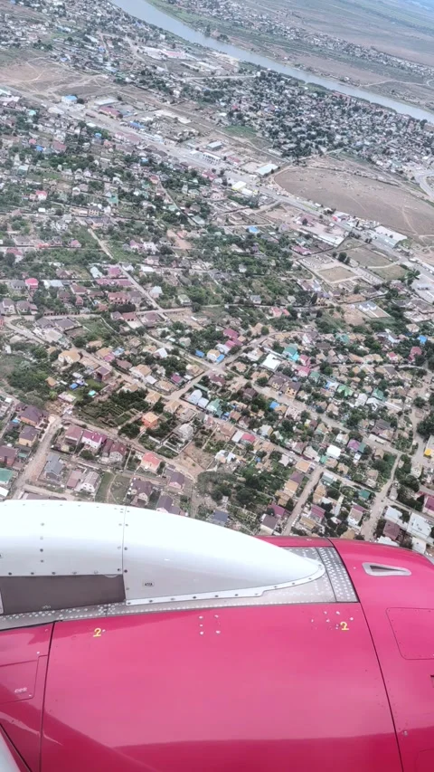 Aerial view from airplane window above green ground, city and river. Air travel. Stock Footage 333667557