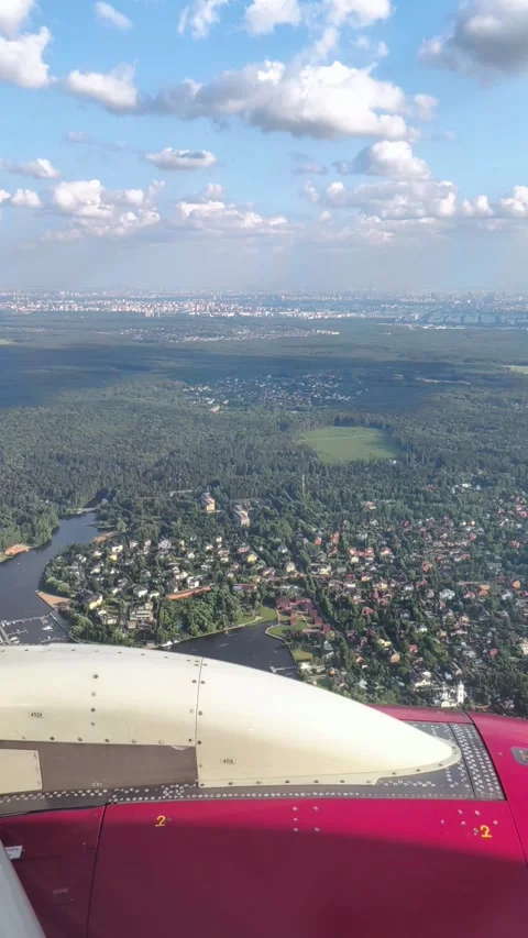 Aerial view from airplane window above green ground, city and river. Air travel. 库存影片 334165609