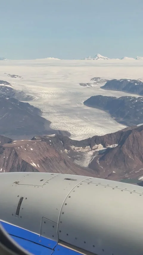 Aerial view from an airplane window featuring snow-covered mountains Stock Footage 312979219