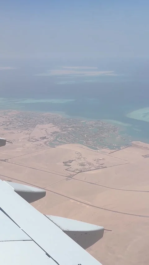 Aerial view from an airplane window flying over the desert and the red sea coast 動画素材 347256053