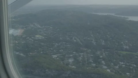 Aerial View from Airplane Window Over Coastal Suburbs and Forest, Sydney Region Stock Footage 345733455