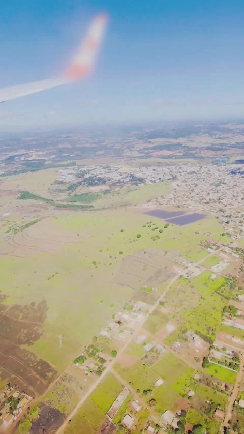 Aerial view from an airplane window with plane shadow over rural landscape. Stock Footage 313299785