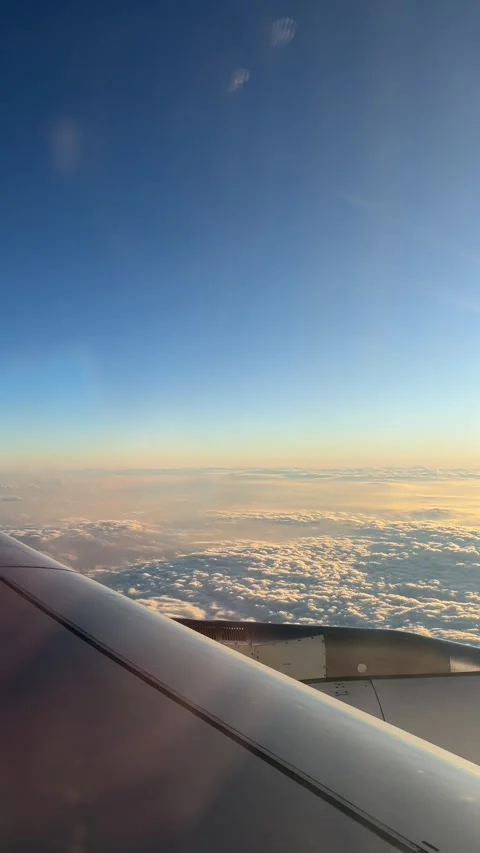 Aerial View of Airplane Wing Above the Clouds at Sunset Stock Footage 320786853