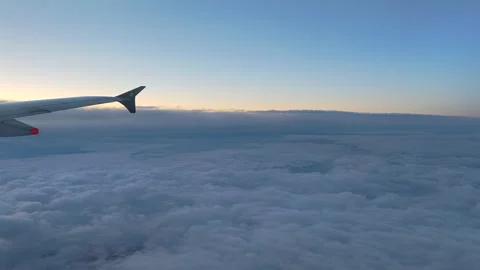 Aerial view of airplane wing flying over majestic sea of clouds at morning Stock Footage 334852760