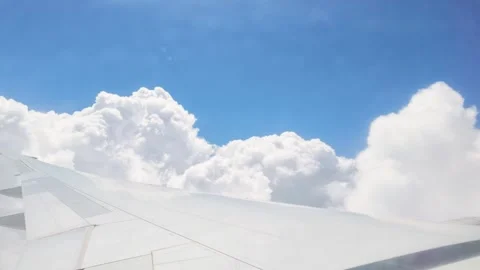 Aerial View of Airplane Wing Flying Past and Through Clouds Stock Footage 346667692