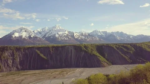 Aerial view of Alaskan river cliffs with mountains in the background Stock Footage 113533121
