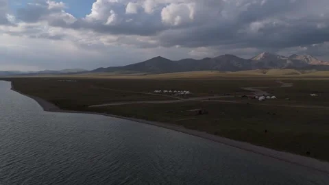 Aerial view along the Song-Kol lake shore under clouds, Kyrgyzstan Stockbeeldmateriaal 347240341
