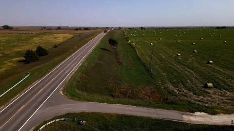 Aerial view along a two-lane highway between harvested fields 스톡 동영상 345531227