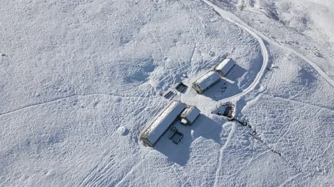 Aerial view of alpine building in winter at the top of snowy mountains Stock Footage 215872237