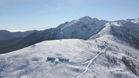 Aerial view of alpine building in winter at the top of snowy mountains Stock Footage 215872850