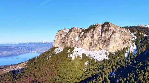 Aerial view of alpine cliff above forest and lake Fotos de archivo