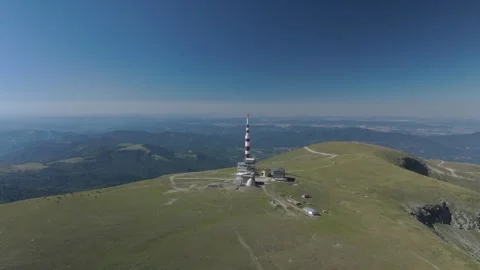 Aerial view of an alpine mountain range with peaks and a communication tower Stock Footage 314342455