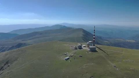 Aerial view of an alpine mountain range with peaks and a communication tower Stock Footage 321367734