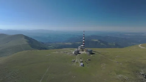 Aerial view of an alpine mountain range with peaks and a communication tower Stock Footage 324016792