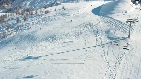Aerial view on alpine ski resort, people snowboarding and skiing, cottages and Stock Footage 228838083