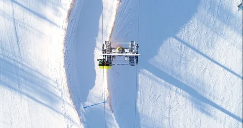 Aerial view of an alpine ski slope and chairlift in action, top down view Stock Footage 103092461