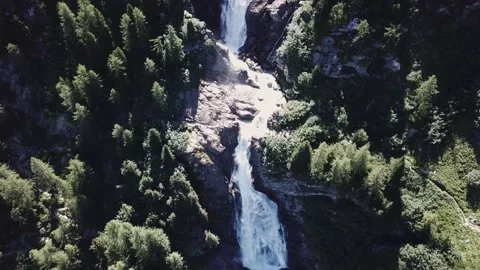 Aerial view - alpine waterfalls with a bridge over it and trekkers Stock Footage 137335376