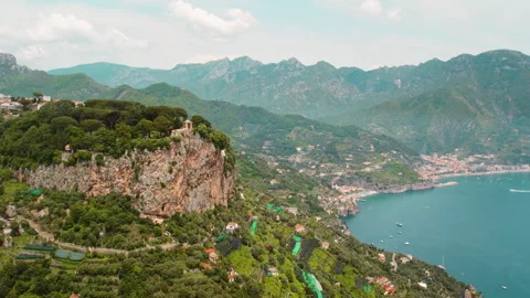 Aerial view of the Amalfi coast with cliffs, greenery, and the coastal town Stock Footage 341354145