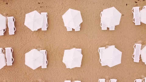 Aerial view of an amazing empty beach with white beach umbrellas Stock Footage 196800938