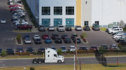 Aerial view of Amazon semi trucks outside an Amazon AWS logistics warehouse in Stock Footage 328294542