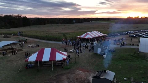 Aerial view of an American fall event with corn maze, striped tents, crowds Stock Footage 322556029