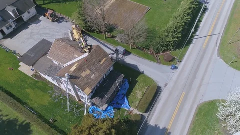 Aerial View of Amish men replacing a roof on an old farm house Stock Footage 128614878