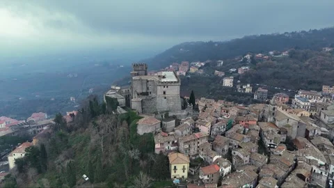 Aerial view of an ancient castle overlooking a quaint village in Italy amid Stock Footage 281335137