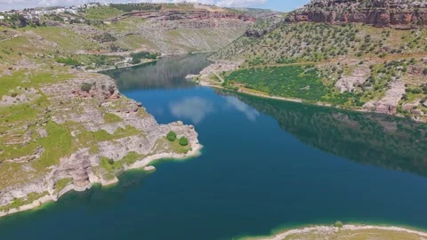 Aerial View of Ancient Cave Ruins Above a Turquoise River Stock Footage 340962325