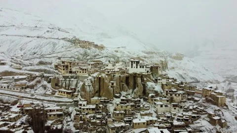 Aerial view of ancient Lamayuru Monastery glowing in winter snowfall. Stock Footage 310661207