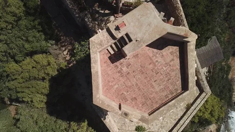 Aerial view - An ancient tower from above on a rocky sea bay in a windy day Stock Footage 94606441