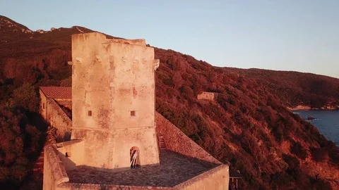Aerial view of an ancient tower on the cliff at Sunset Stock Footage 106540787